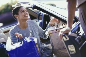 Mature woman sitting in a car carrying shopping bags
