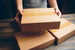 Girl's hands holding the package on the table.